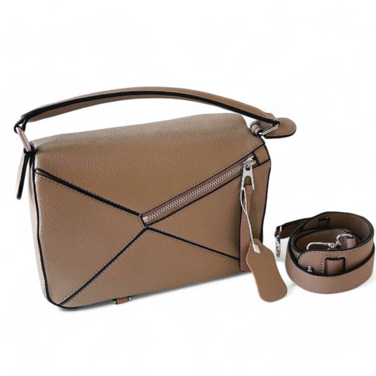 Back view of Amy, a women’s vegan leather handbag in Sand with a zip pocket, geometric panels, top handle, and crossbody strap beside it.