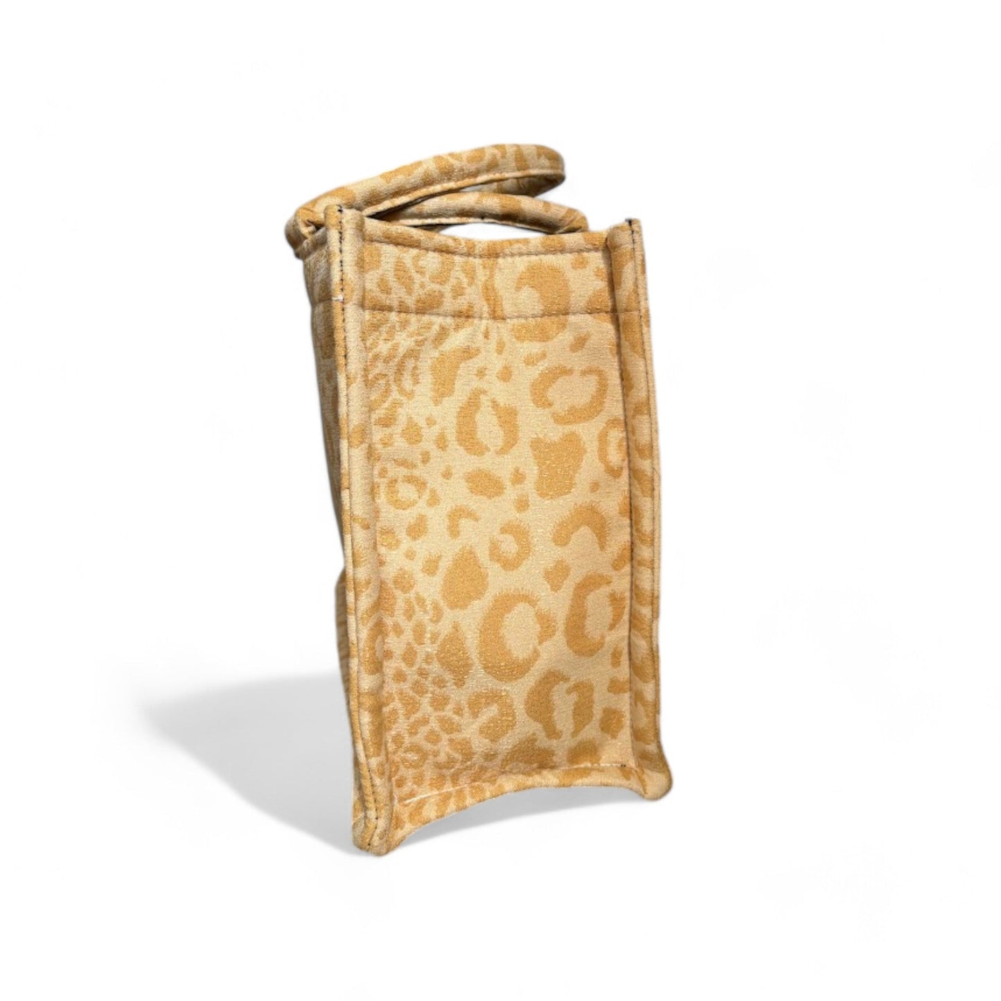 Side view of a yellow leopard print tote bag displaying its structured shape and reinforced seams.