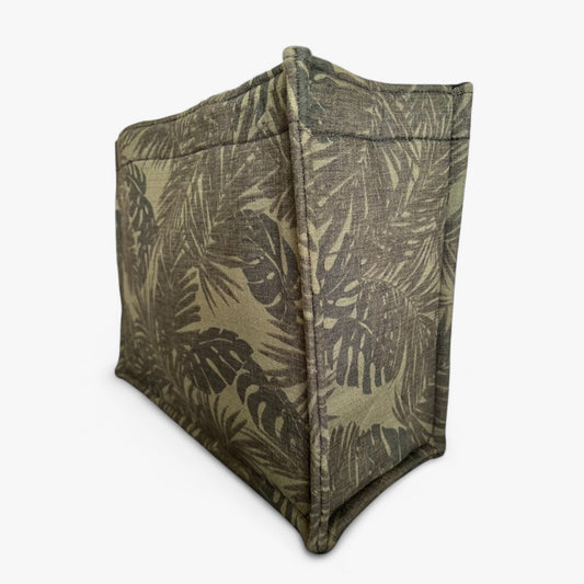 Side view of a green textured tote with monstera and palm leaf patterns.