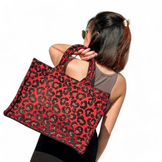 A model wearing a handmade leopard print book tote bag over the shoulder, showcasing its spacious design.