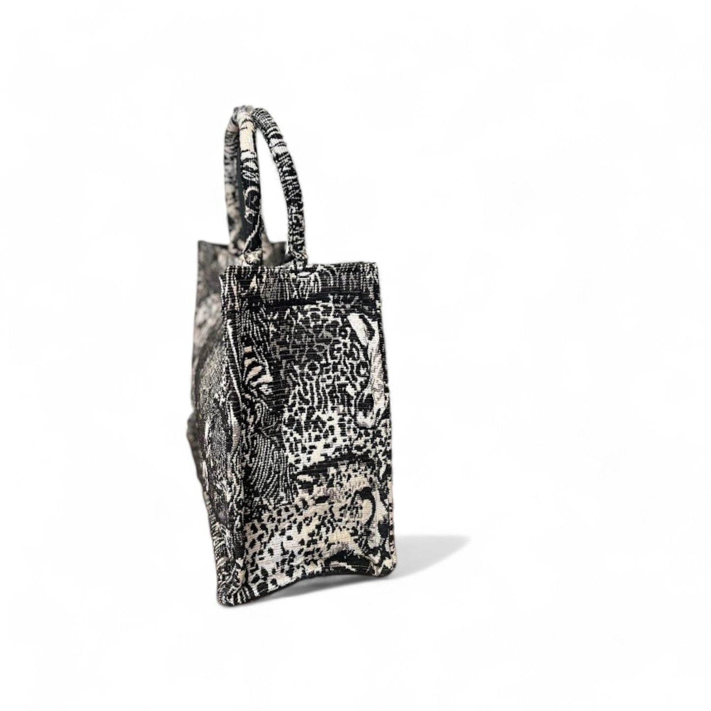 Safari animal-patterned tote bag in black and beige tones with double handles and sturdy side panels.