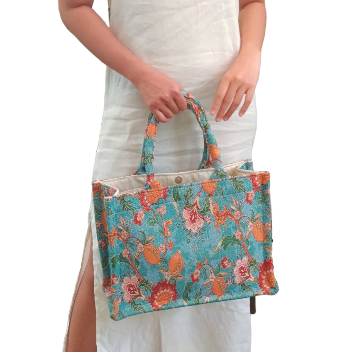 A person holding the maxi blue vintage floral tote bag, showing how it looks when carried.