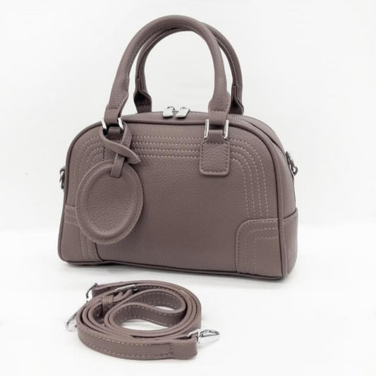 Celeste, a PU leather bowling bag in taupe with top handles, silver hardware, and a detachable, adjustable shoulder strap.