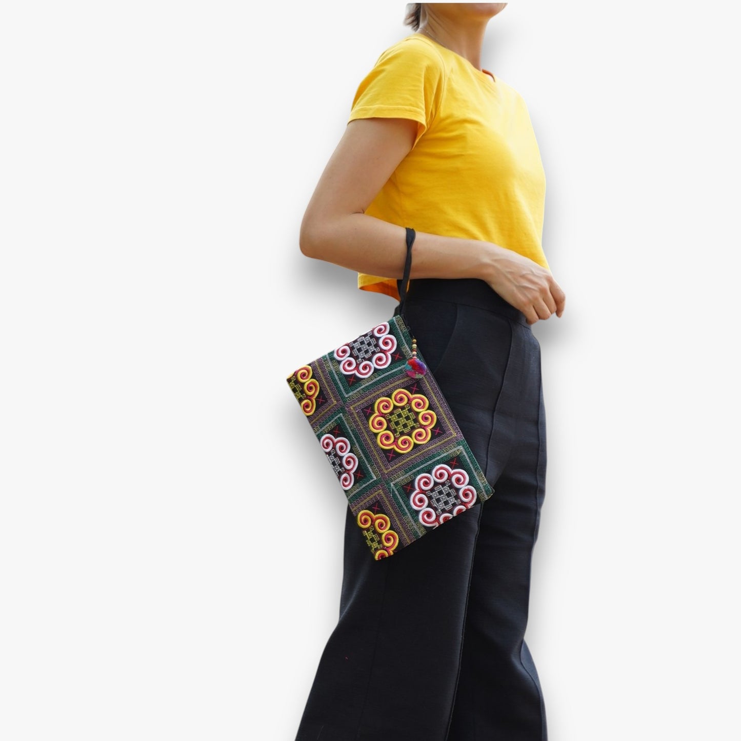 Handmade ethnic clutch wristlet with colourful embroidery worn as a fashion accessory.