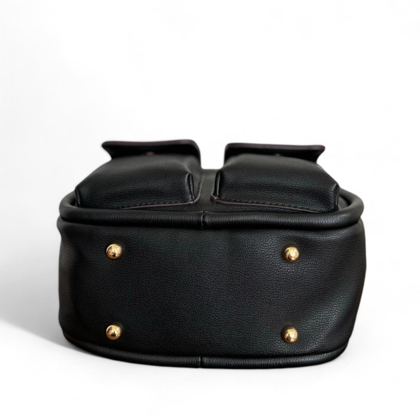 Bottom view of black faux leather Dougie bag with two front flap pockets and 4 gold-tone stud feet hardware.