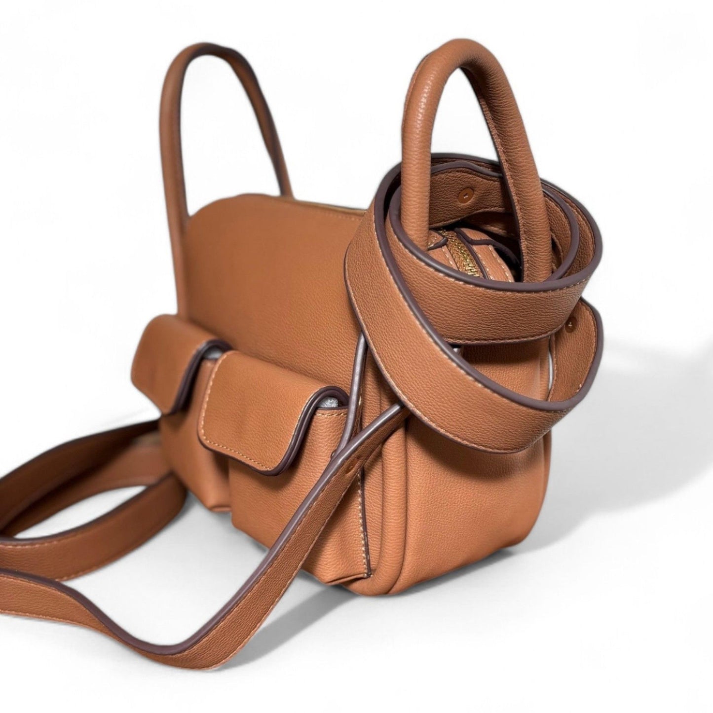 Close-up of brown faux leather Dougie bag showing long strap attached and short strap wrapped around top handles.