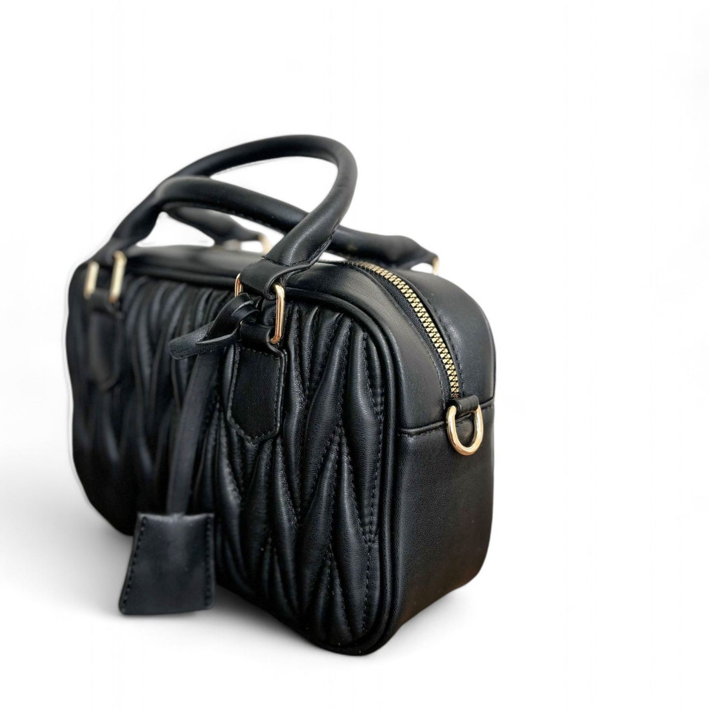 Angle view of black handbag with a quilted pattern, featuring gold-tone hardware and top handles.