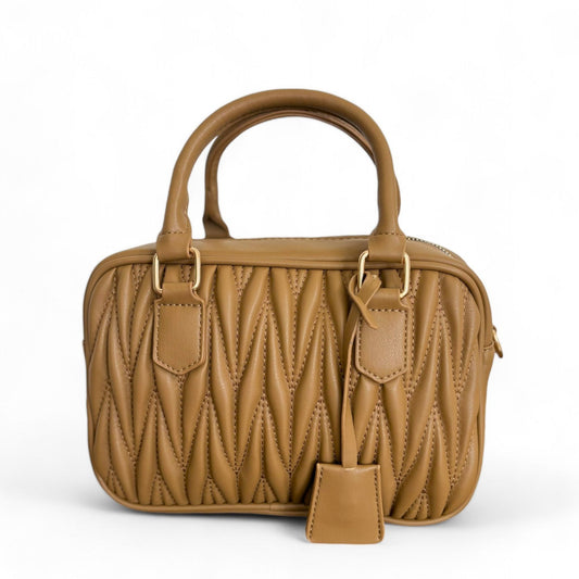 Front view of a caramel handbag with quilted pattern, gold-tone hardware, and top handles.