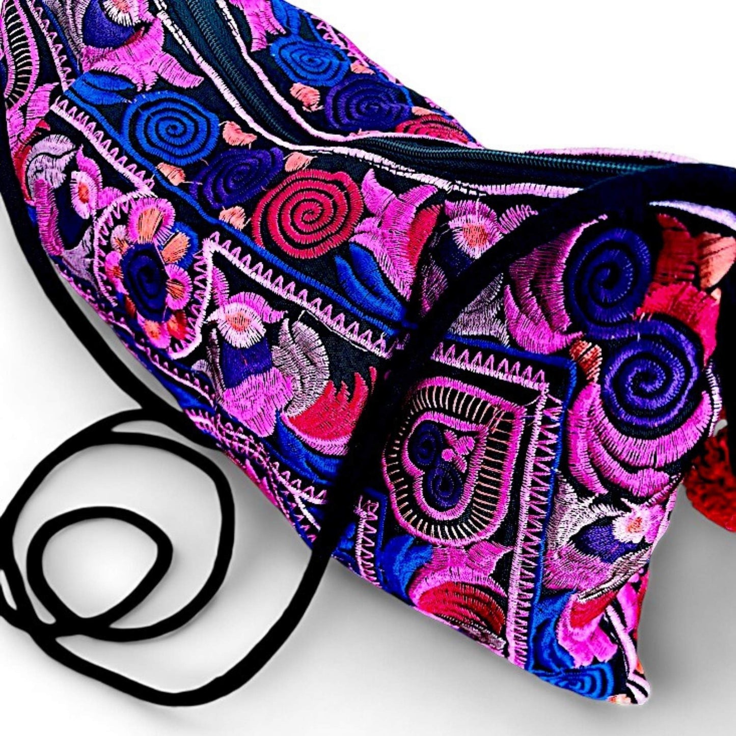 A close-up of a pink multi-coloured embroidered bag featuring intricate floral and bird patterns.