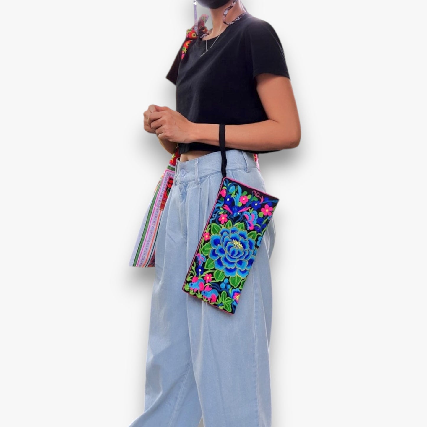 A person carrying a blue floral-patterned bag with a strap on their arm.