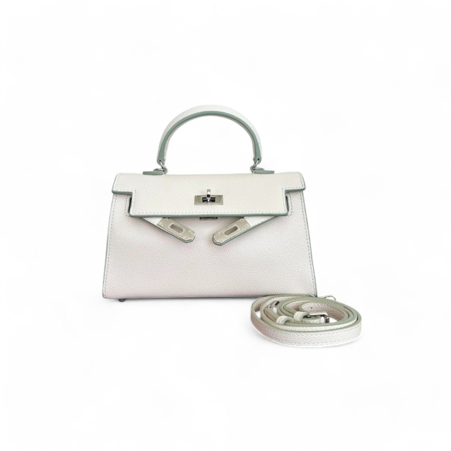 White mini top-handle bag with silver hardware, a flap closure & a shoulder strap shown beside the bag.
