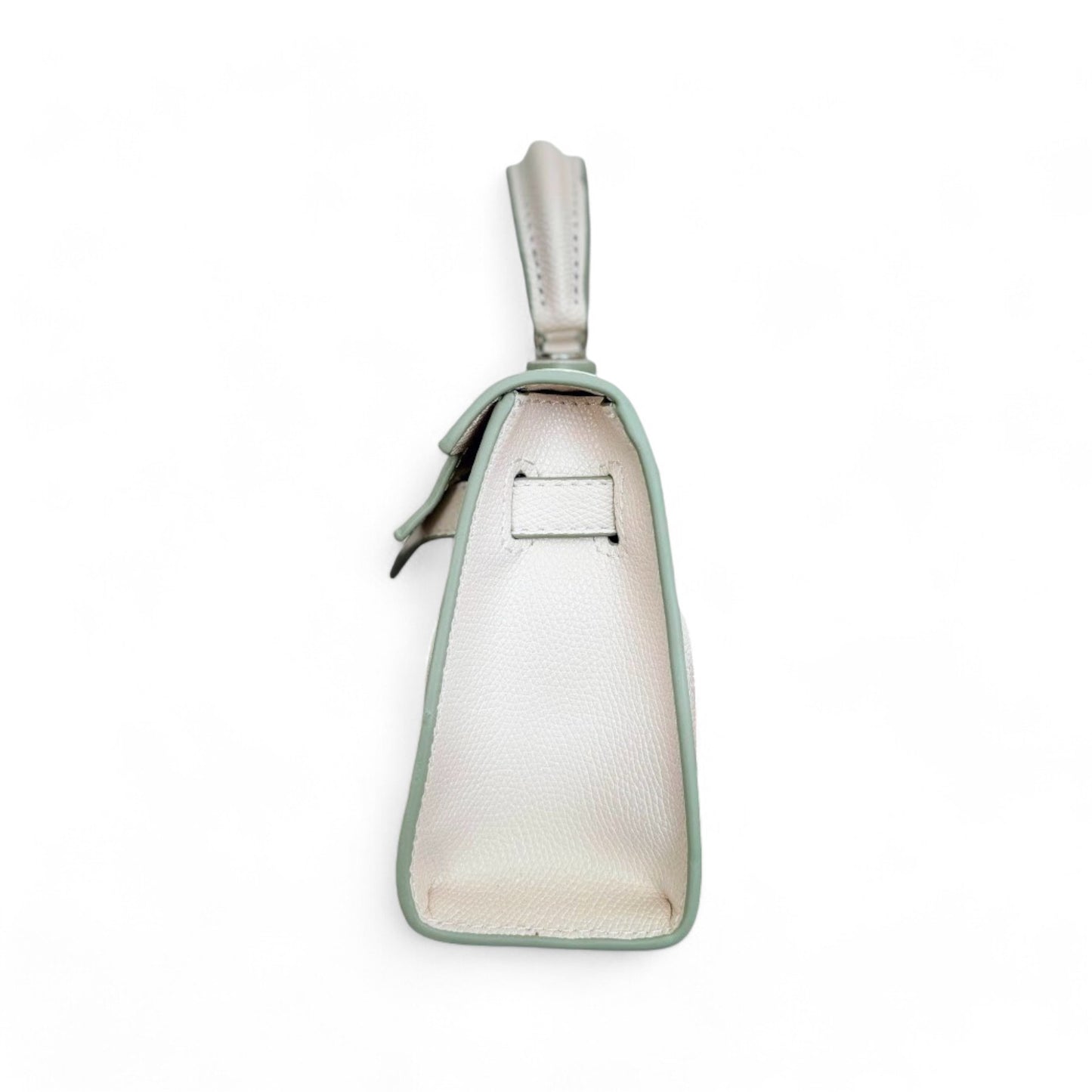 Side view of white mini top handle bag with side strap and structured base.