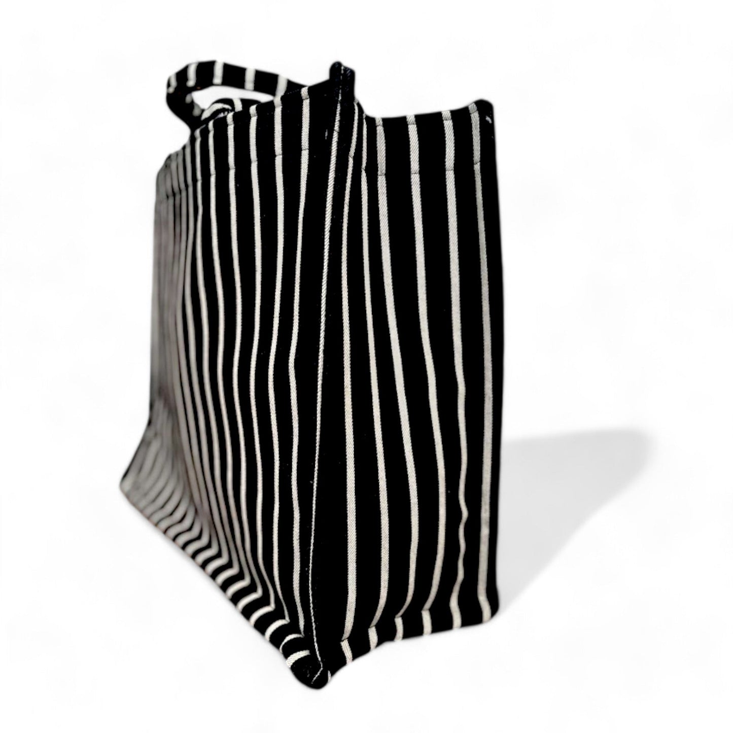 Side view of a large black and grey striped tote bag showcasing its spacious and sturdy structure.