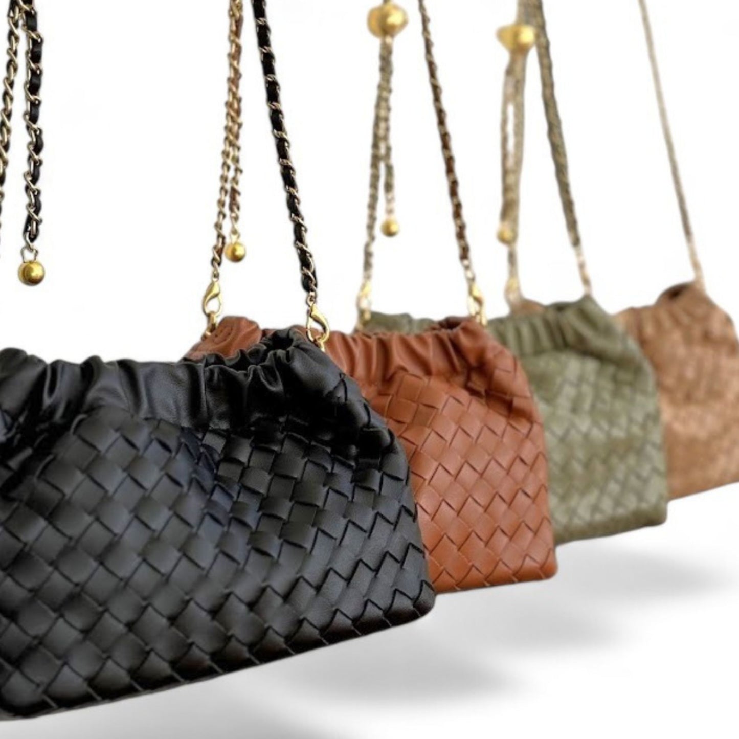 Close-up of row of woven pattern bags in black, brown, sage, and tan, featuring ruched tops and gold chain strap.