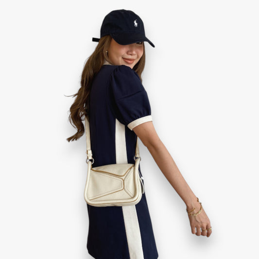 A woman wearing a white puzzle-inspired casual everyday crossbody bag.