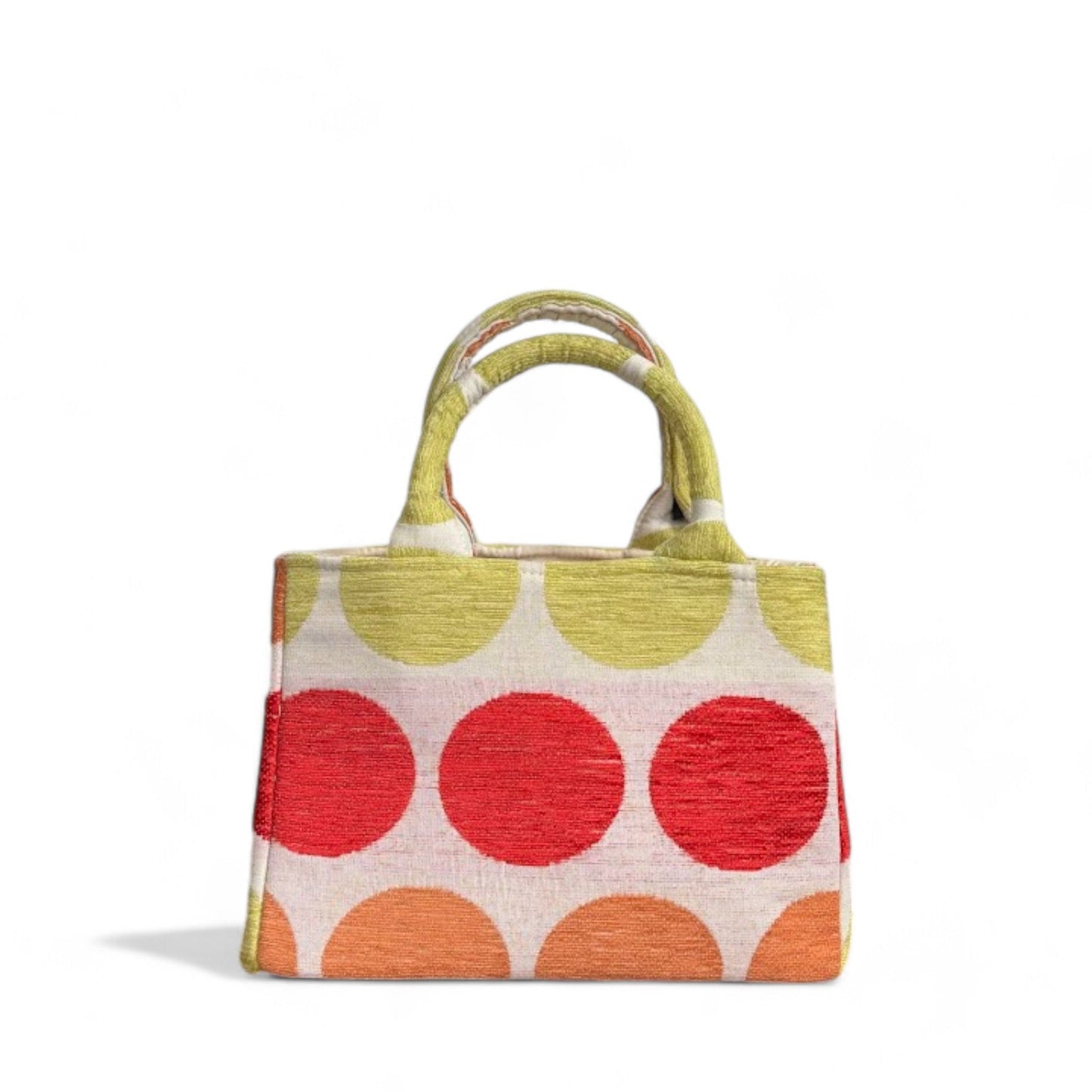 Mini tote bag with a top handle features large dots in vibrant red, green, and orange on beige fabric.