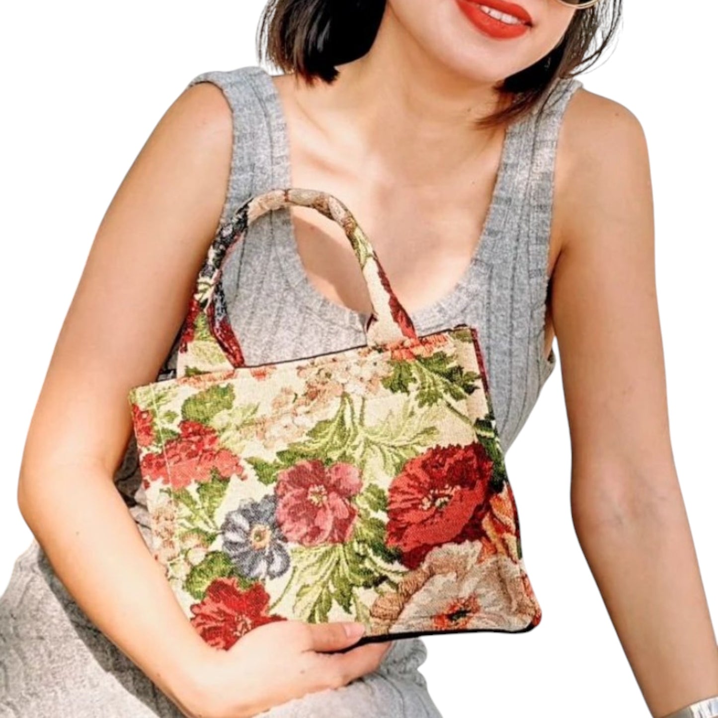 A model holding the bottom of a mini tote bag with floral patterned in her hand.