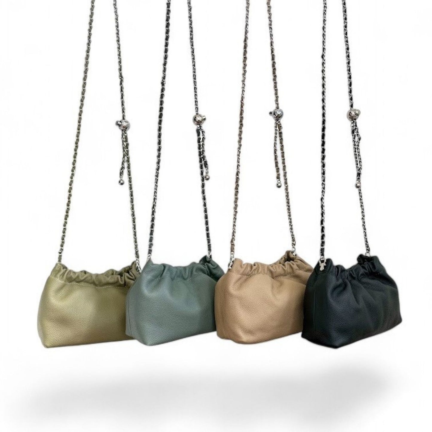 A row of black, beige, green, and dark blue handbags each with chain strap.