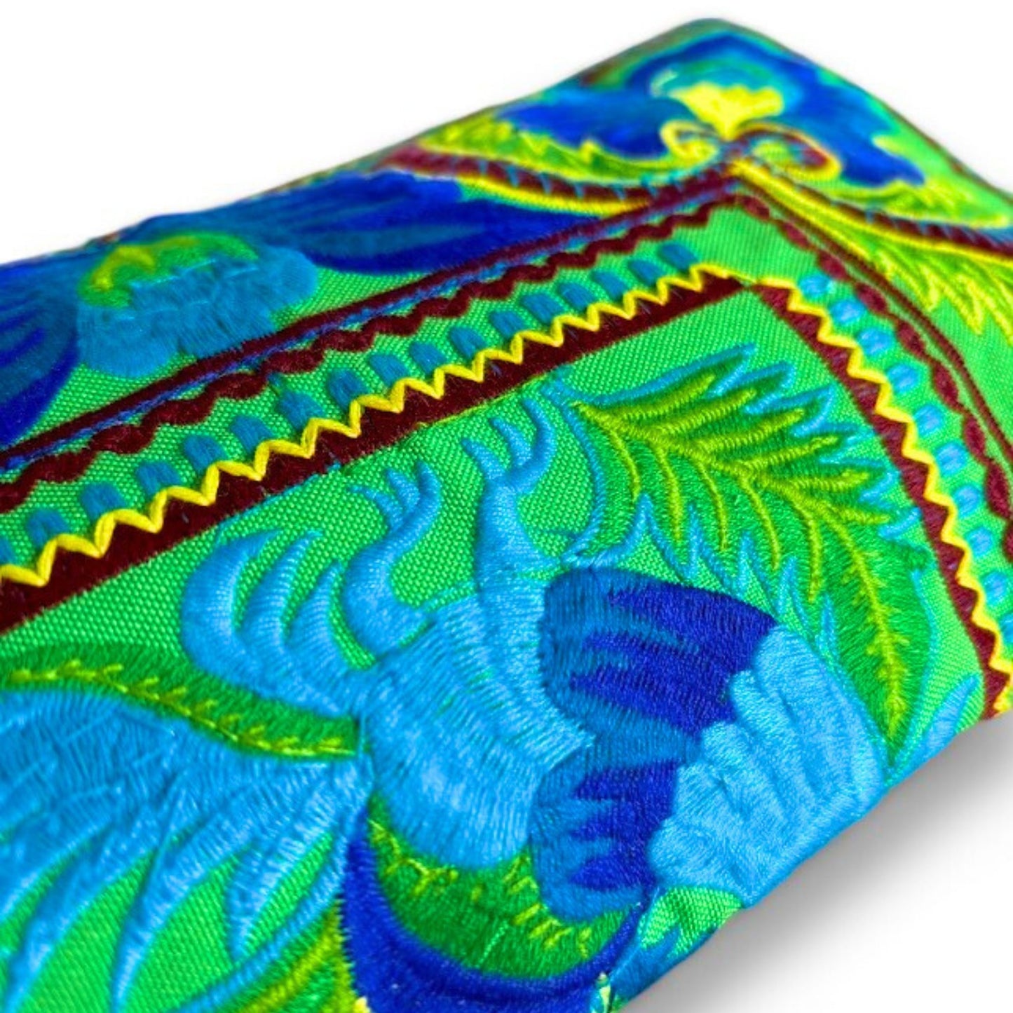 Close-up of handmade Green Peacock wristlet showing intricate Hmong embroidery with vibrant blue and green.