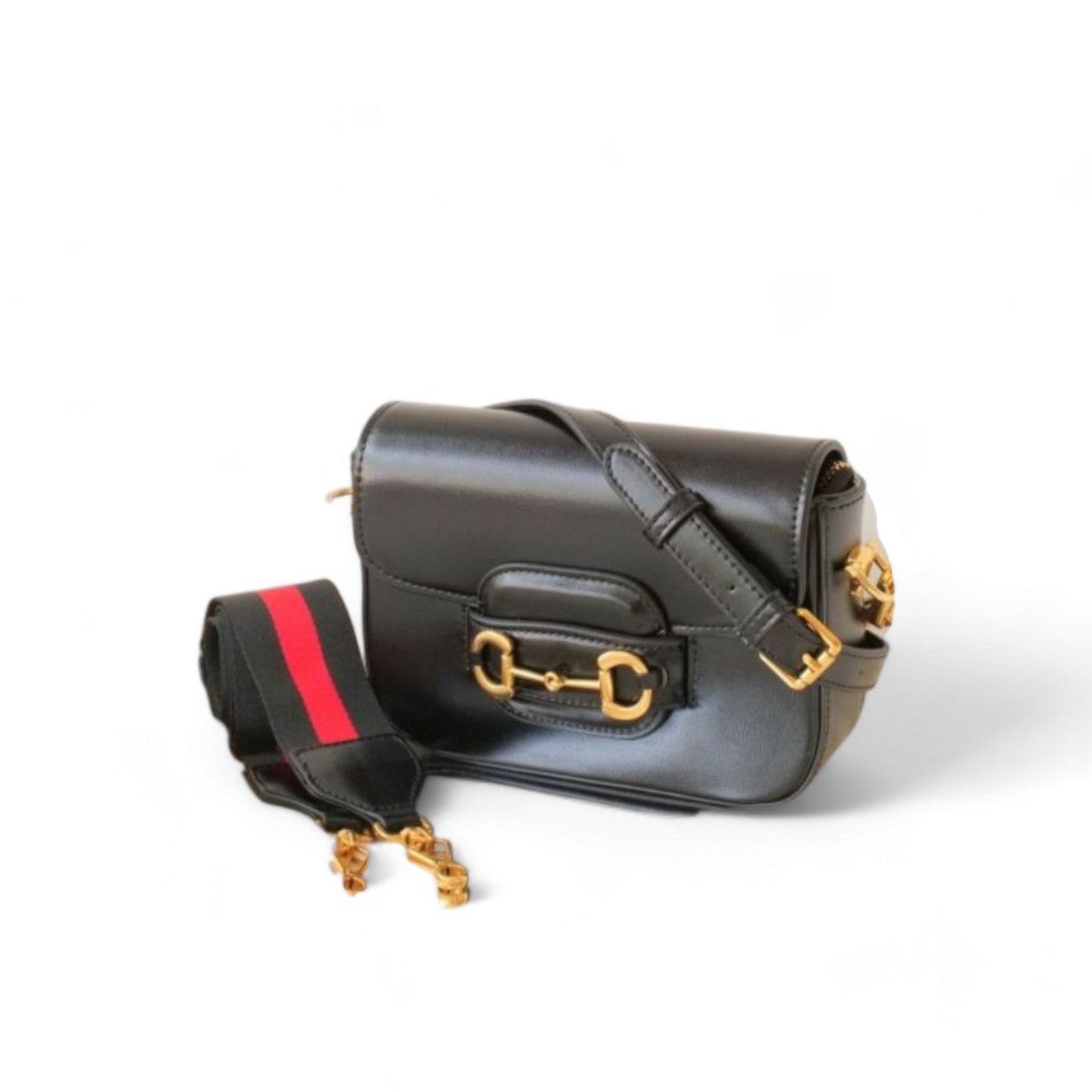 Black leather bag with gold accents, featuring a slim, smooth leather strap and a wider nylon strap.