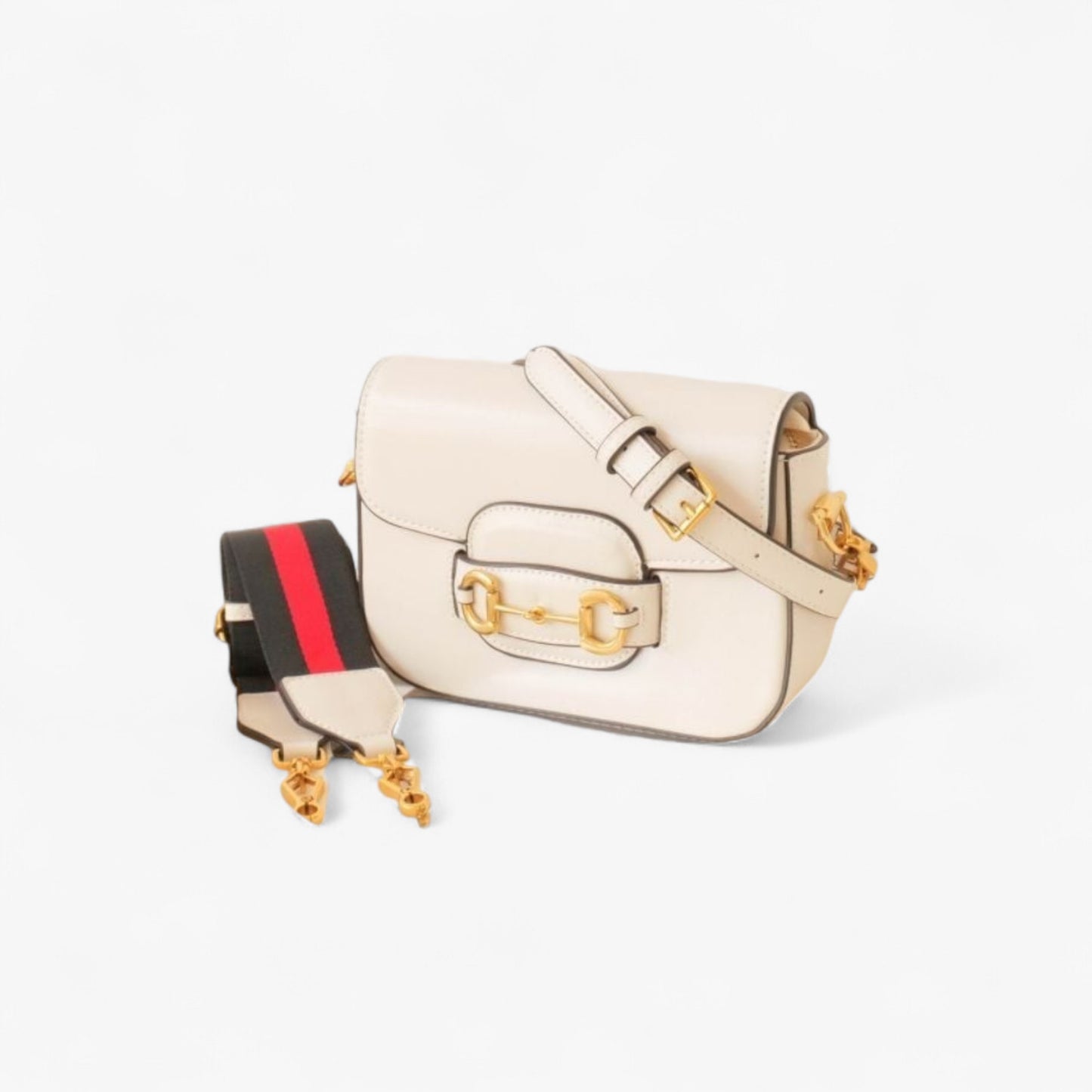 White leather bag with gold accents, featuring a slim, smooth leather strap and a wider nylon strap.