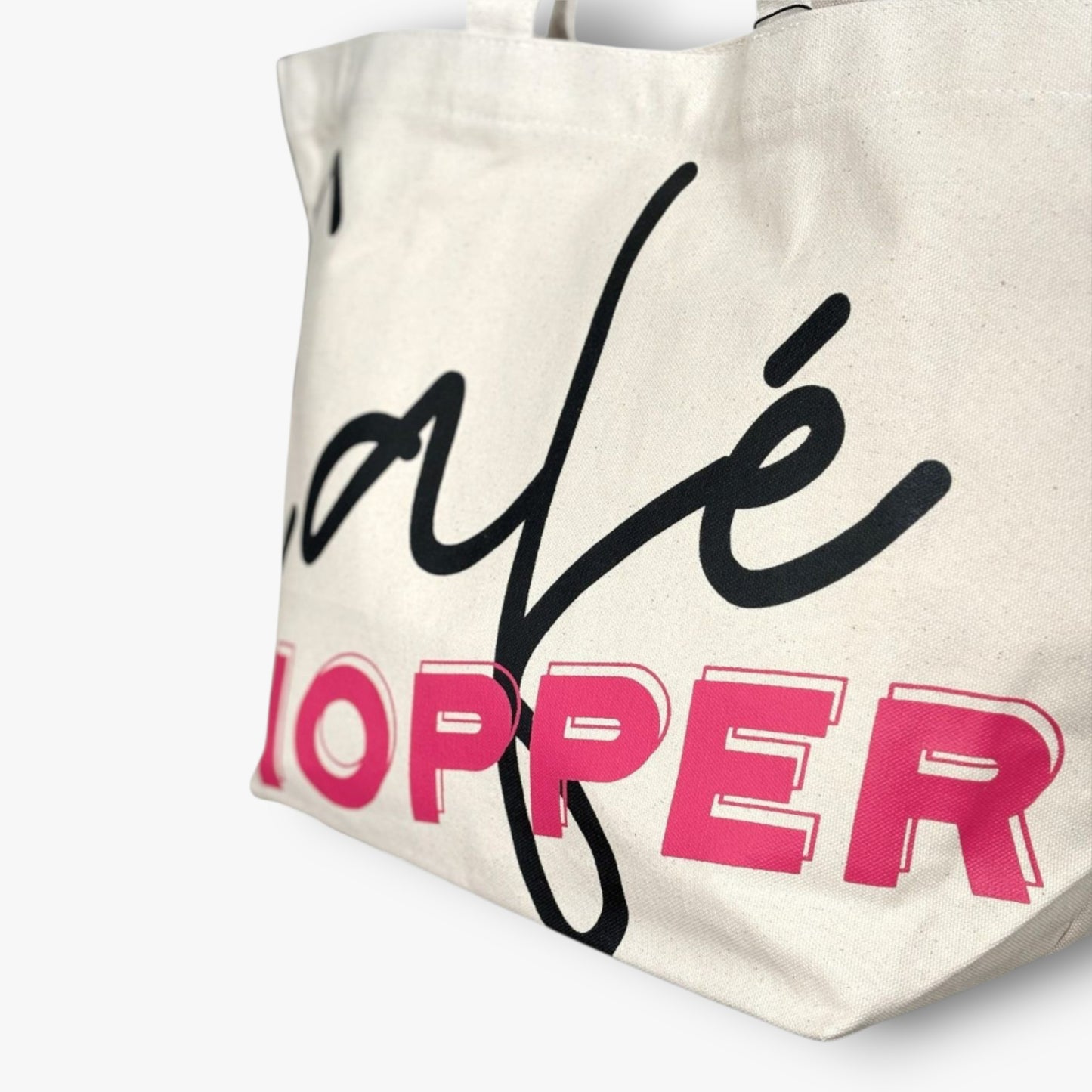 Detail shot of Café Hopper tote highlighting trendy lettering print on durable canvas.
