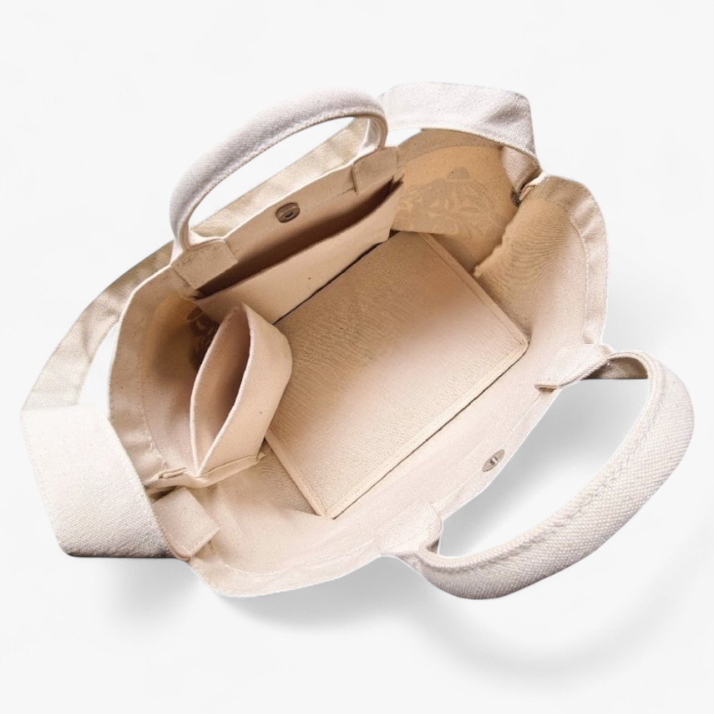 Top view of a canvas tote with a shoulder strap, top handles, a pocket, a bottle holder, and a strong base.