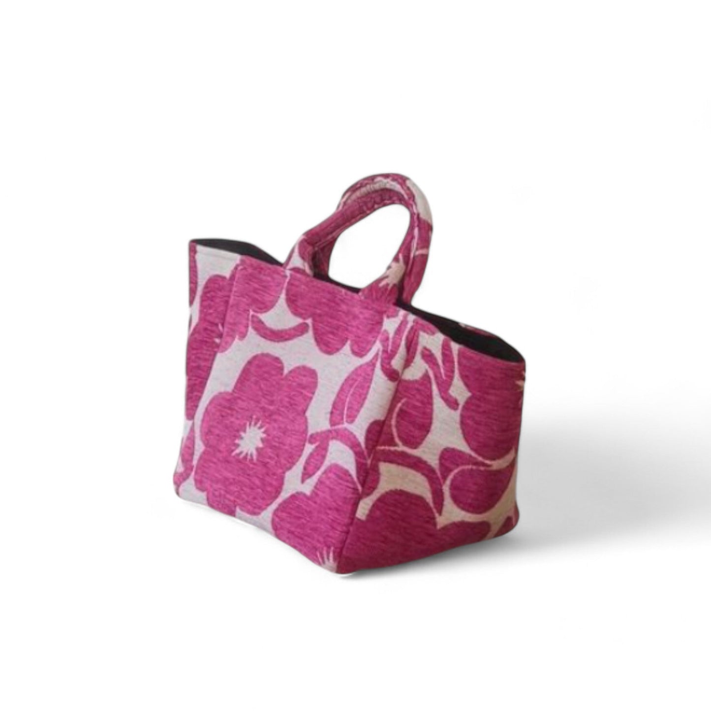 The bag with top handles stands upright, highlighting its durable base and bright magenta floral design.