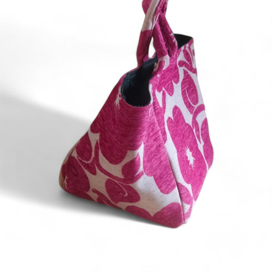 A side view of a magenta floral chenille tote bag, showing its spacious shape.