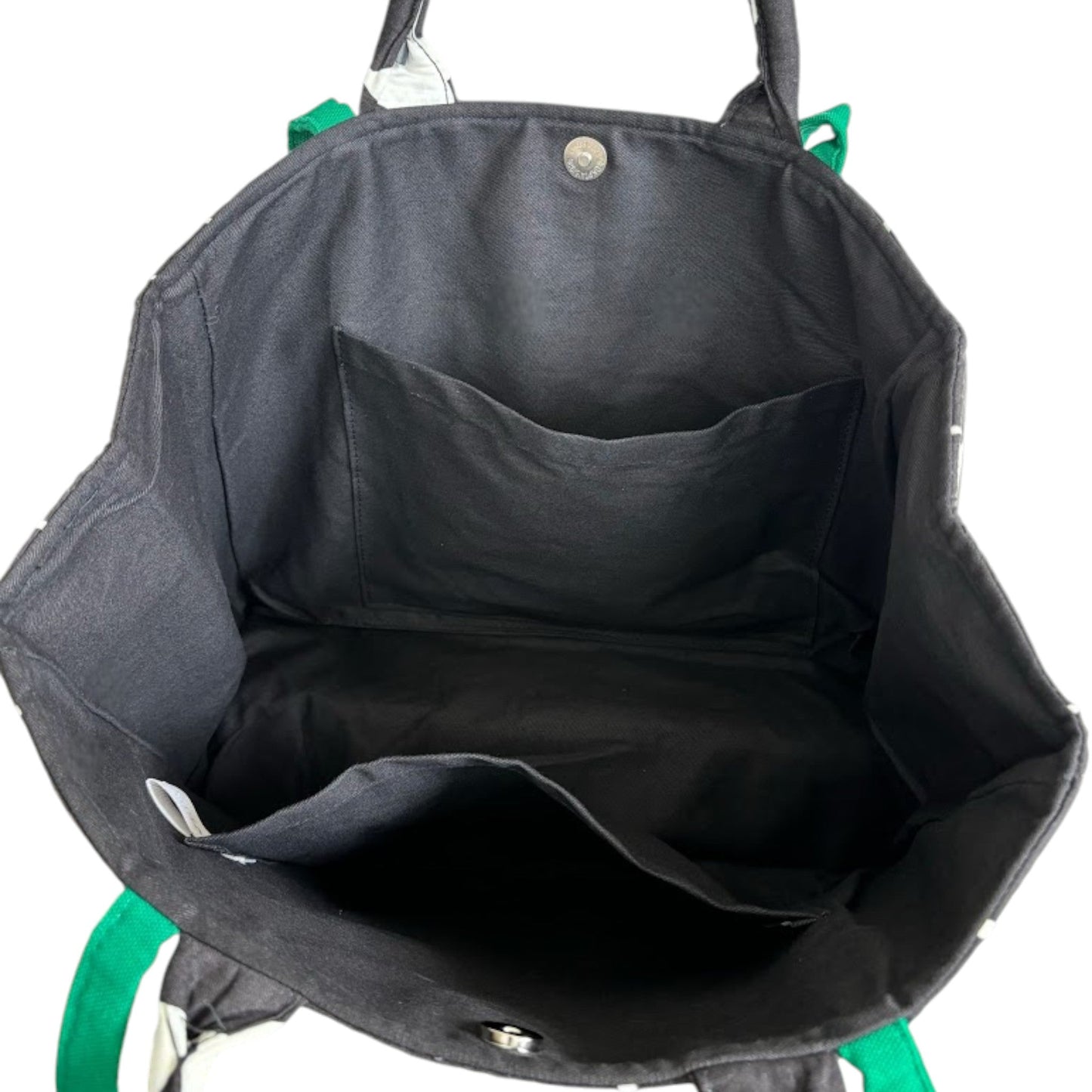 An opened tote bag showing two large slip pockets, black fabric lining, and magnetic clasp closure.