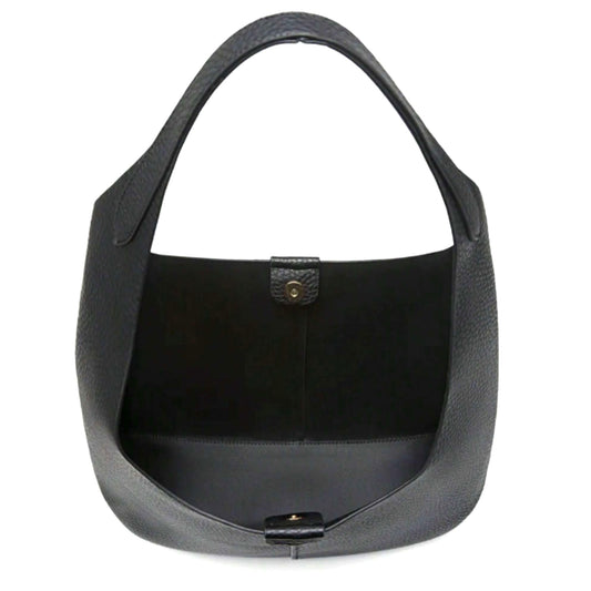 Interior of a black hobo bag with a single compartment and magnetic snap buttons.
