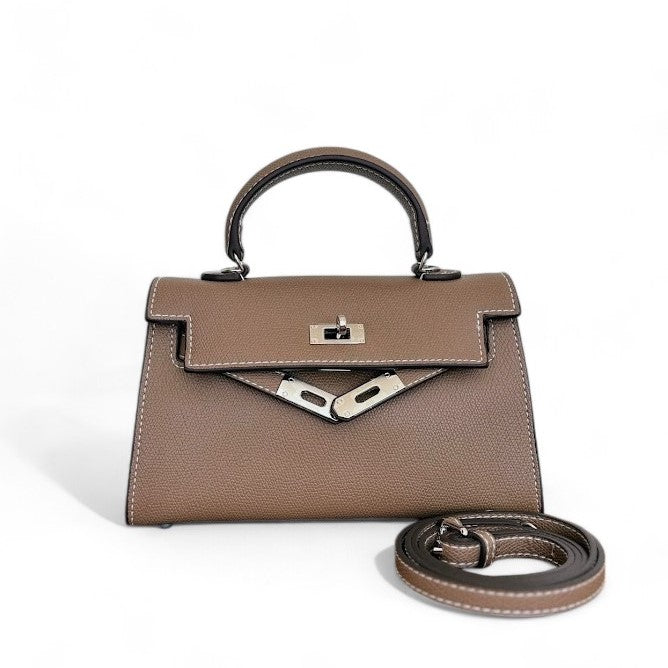 Taupe mini top-handle bag with silver-tone hardware, flap closure & adjustable shoulder strap shown beside the bag.