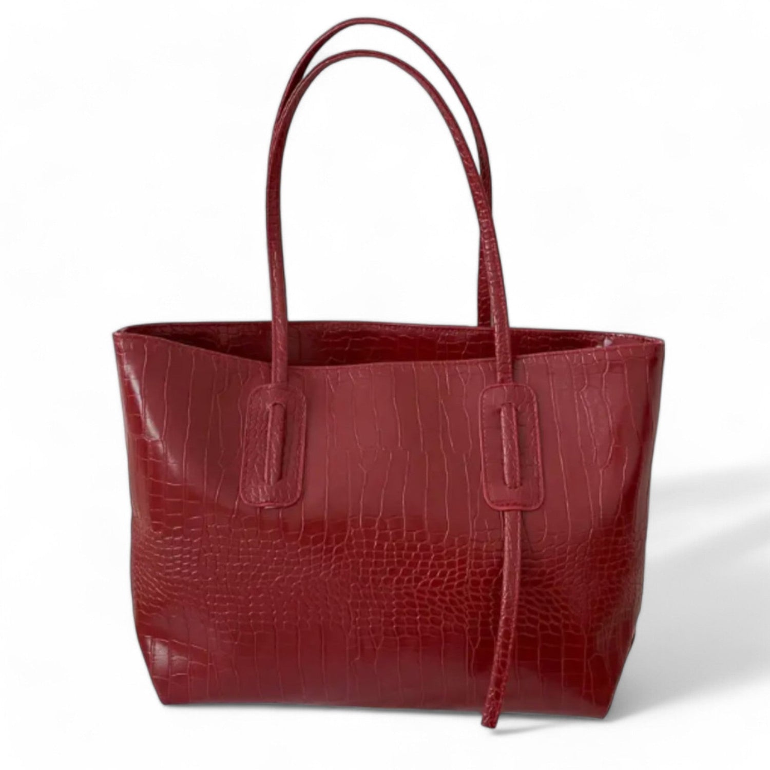 A minimalist burgundy tote bag with a crocodile-textured finish and double straps.