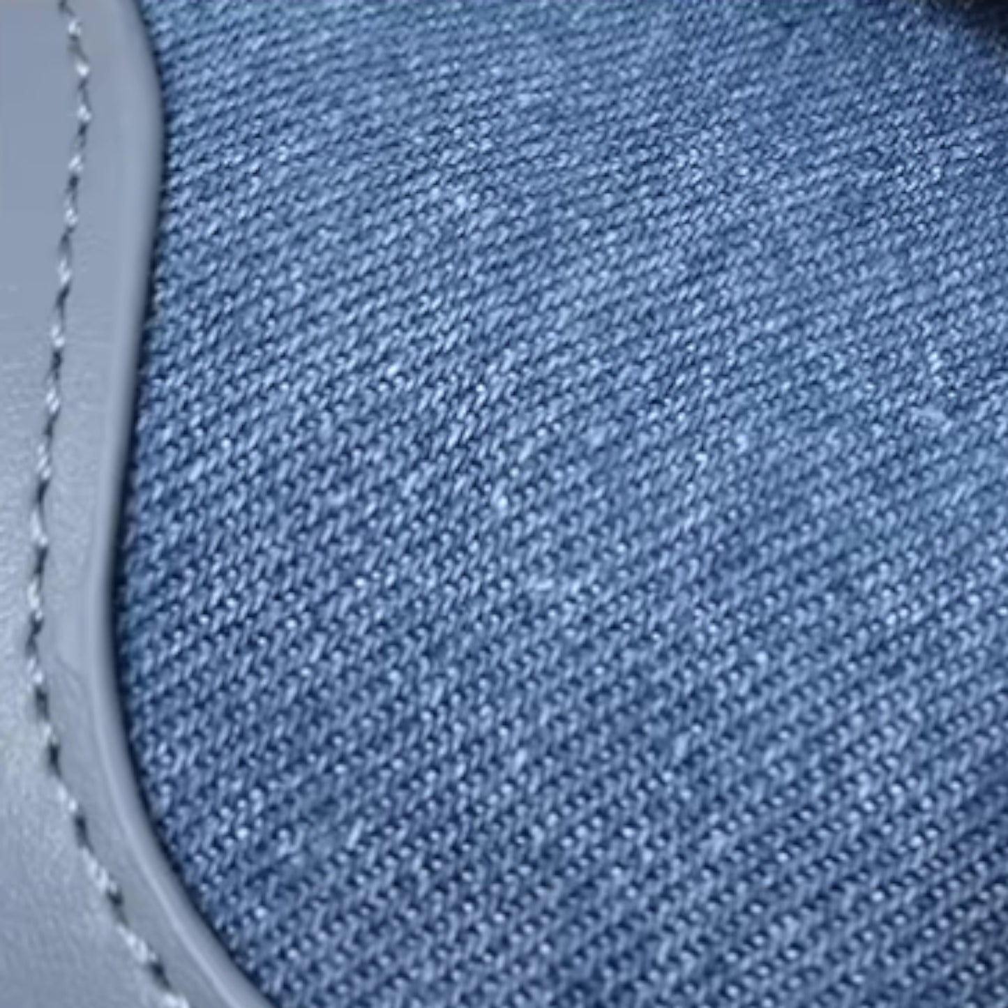Close-up of blue denim fabric with stitching detail. Ideal for casual everyday style.