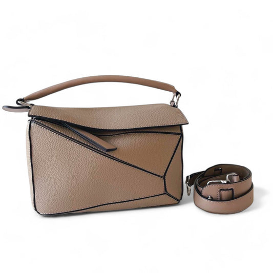 A beige handbag with geometric panels, top handle, and adjustable crossbody strap is shown beside the bag.
