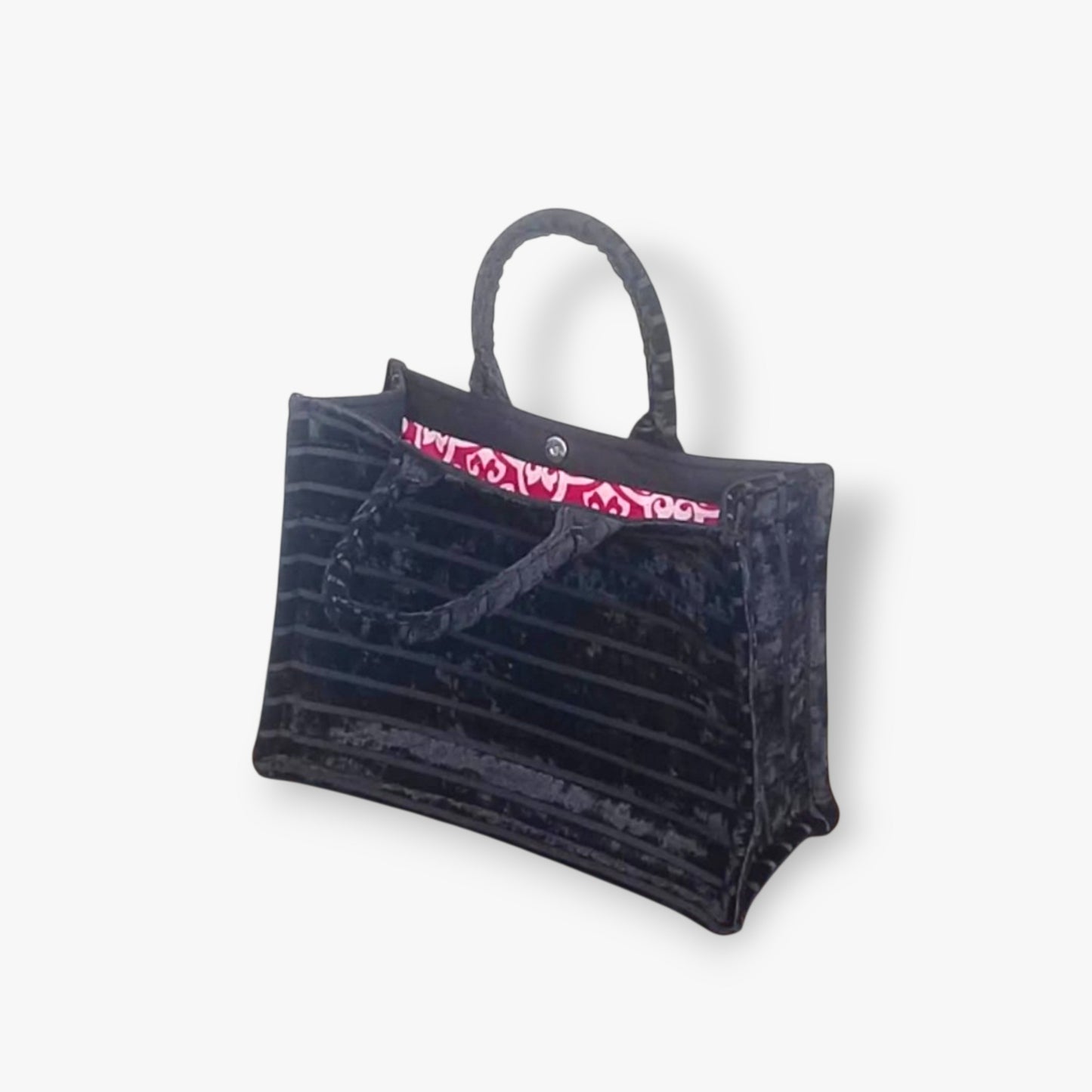 An elegant black tote bag with horizontal textured stripes and raspberry damask-patterned lining.