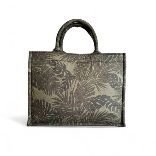  Front view of a book tote featuring black and green monstera and palm leaf patterns.
