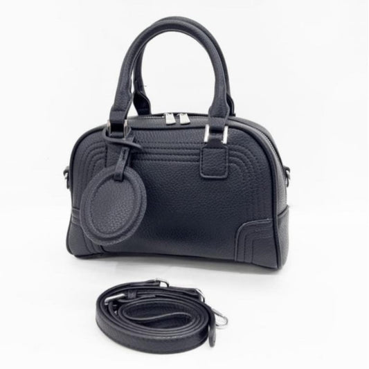 Celeste, a PU leather bowling bag in black with top handles, silver hardware, and a detachable, adjustable shoulder strap.