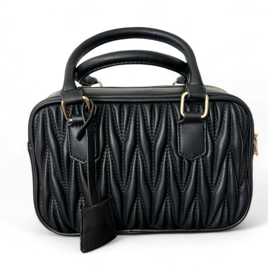 A black handbag with a quilted pattern, featuring gold-tone hardware, double top handles, and a zipper closure.