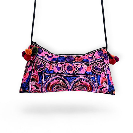 A pink multi-colour Hmong embroidered crossbody bag with colourful mini pompom charms.