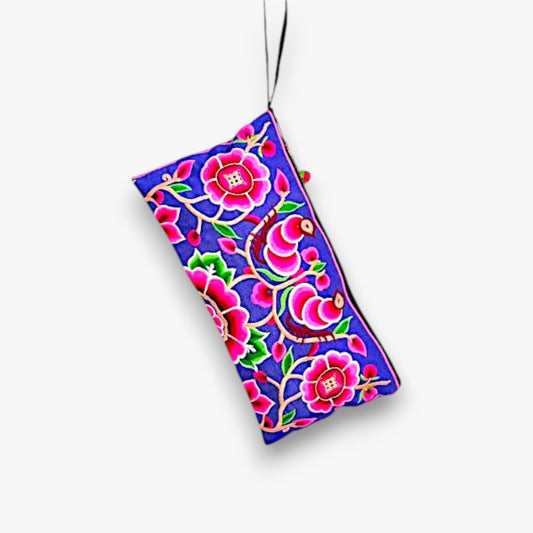 Front view of a vibrant pink clutch with Hmong peony embroidery and wrist strap.