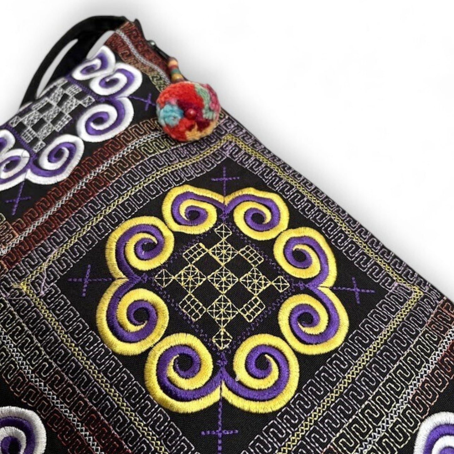 Close-up of an embroidered fabric with intricate Hmong traditional patterns.