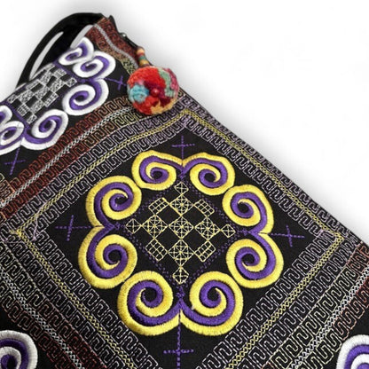 Close-up of an embroidered fabric with intricate Hmong traditional patterns.