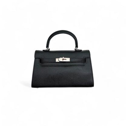 Front view of black mini top-handle bag with silver hardware and flap closure.