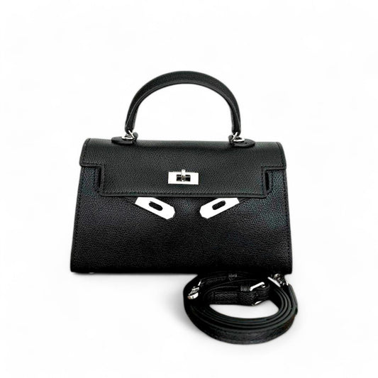 Black mini top-handle bag with silver hardware, closed flap & adjustable shoulder strap shown beside the bag.