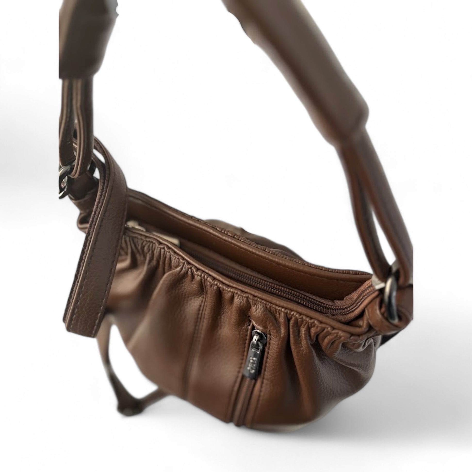 Top view of a dark brown bag with pleated detailing, a top handle, a shoulder strap, and zip pockets on the top and front.