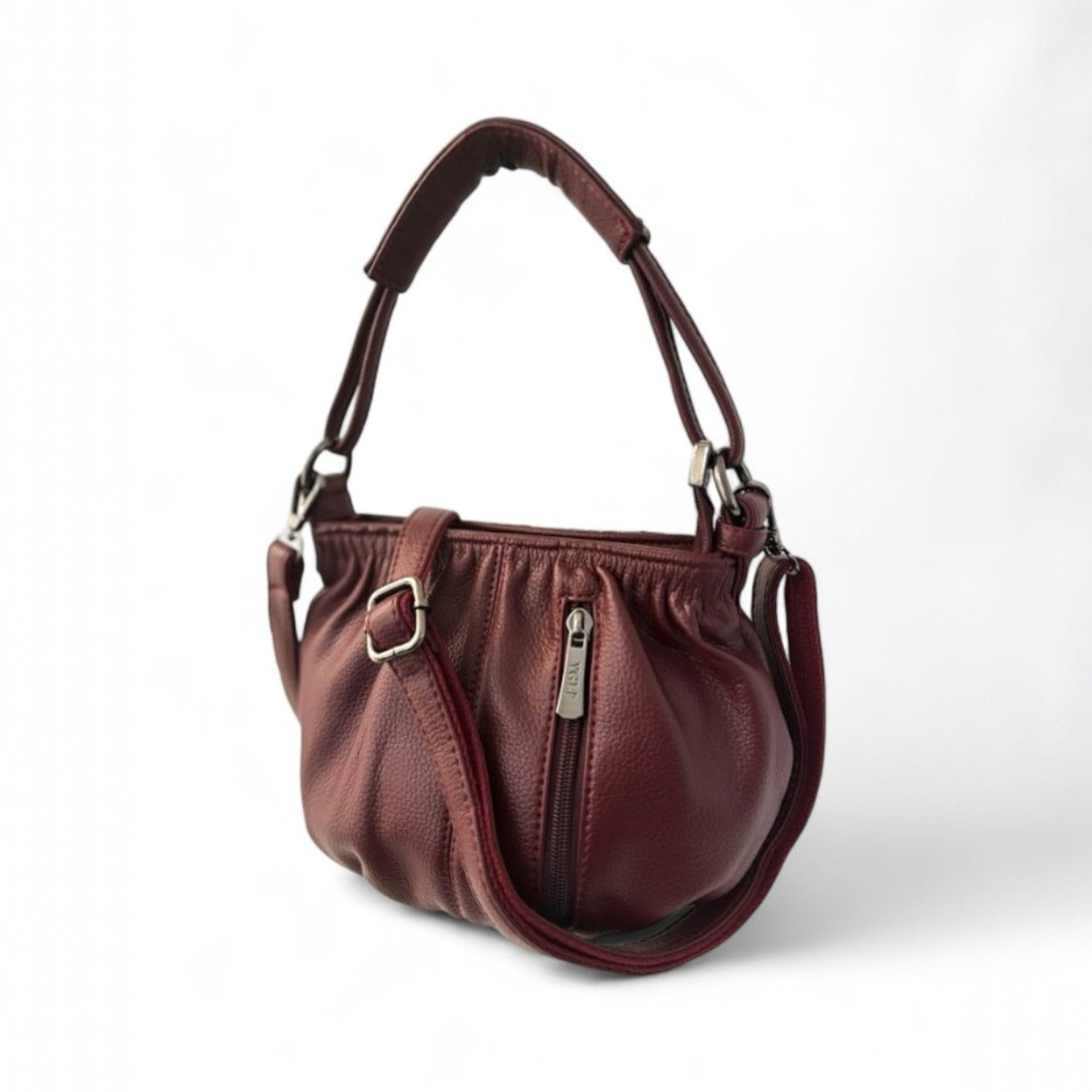 Angle view of a maroon pleated bucket bag with a vertical front zip pocket, a top handle and a shoulder strap.