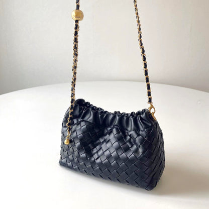 Black Intrecciato-style mini bag with gold chain strap and ornate gold length-adjusting button.