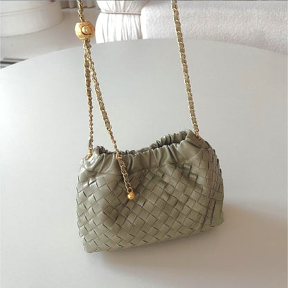 Sage green woven mini bag with gold chain strap and ornate gold length-adjusting button.