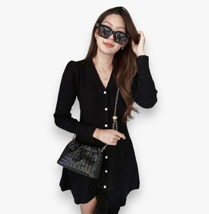 A woman worn a stylish black woven bag with a gold chain across her body.